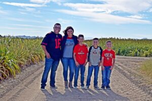 adorable family with three boys dressed in football jerseys