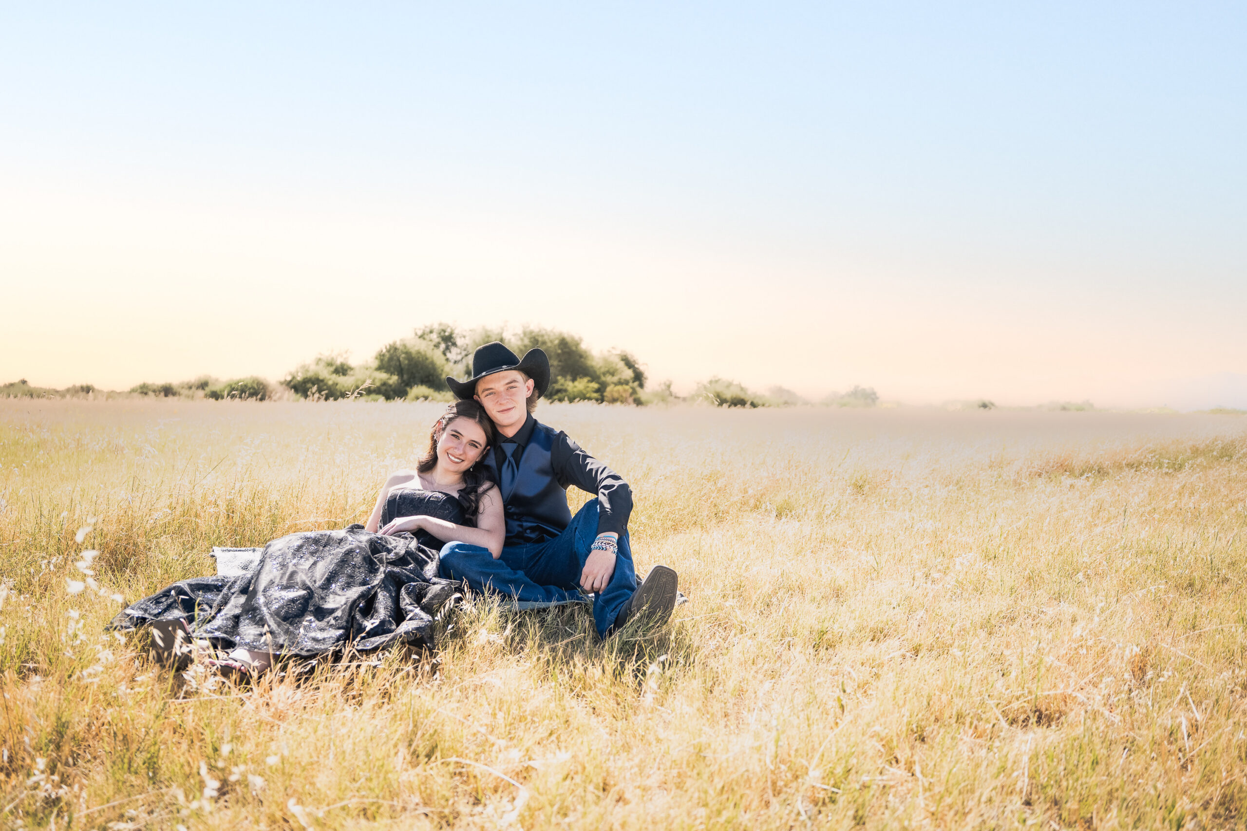Brem and Addie posing in a Goodyear Arizona field before prom
