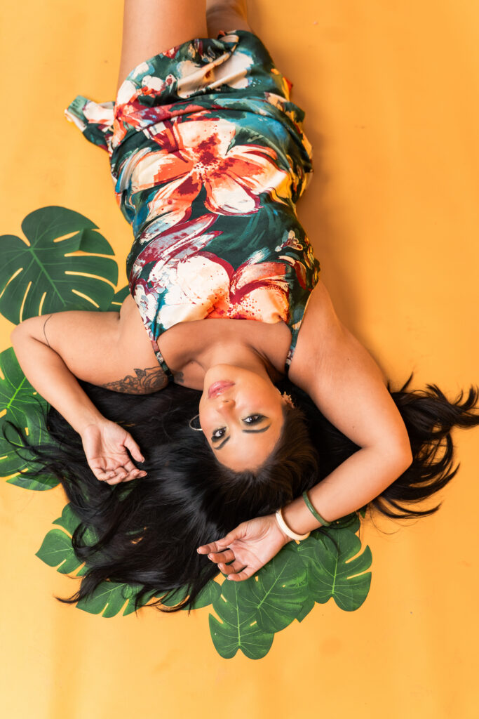 TC wearing an emerald green and coral tropical dress