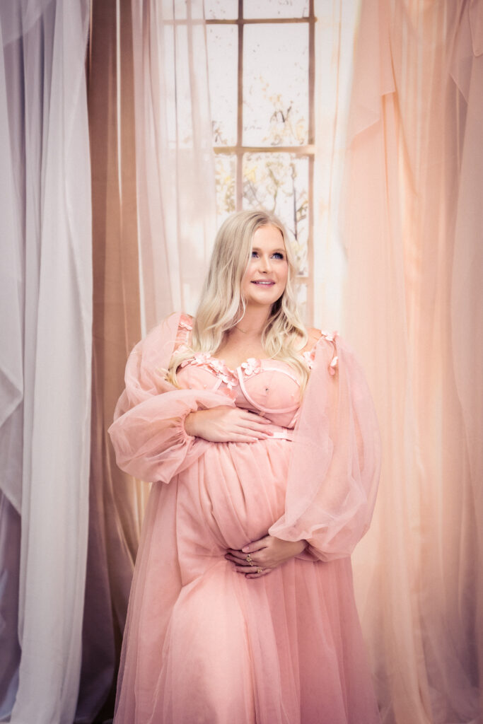 Studio portrait of Kelsey in a flowing pink gown against a dreamy window backdrop at Vision Studio in the West Valley of Phoenix.