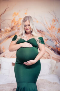 Studio portrait of Kelsey in a gorgeous green gown against a dreamy fall foliage backdrop at Vision Studio in the West Valley of Phoenix.